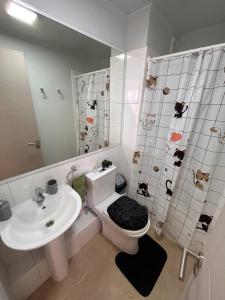 a bathroom with a toilet and a sink and a shower at Condominio Nuevo Lantaño Chillán in Chillán