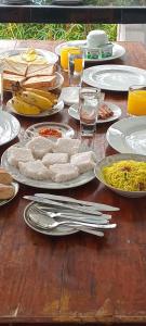 a wooden table with plates of food on it at Sadhara River View Lodge in Kandy