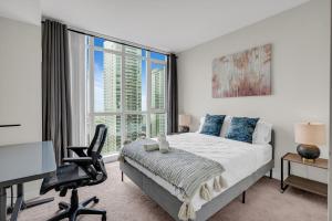a bedroom with a bed and a desk and a window at Breezy Lake And City Views - One Free Underground Parking in Toronto