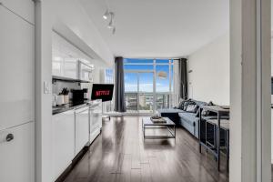 a kitchen and living room with a couch and a table at Breezy Lake And City Views - One Free Underground Parking in Toronto