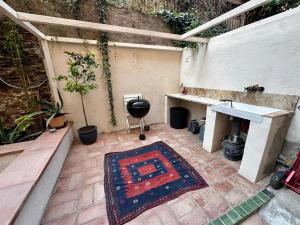 un patio con un tavolo e un tappeto sul pavimento di PORT VENDRES - Charmant T2 avec terrasse à 200m du port - FR-1-309-537 a Port-Vendres