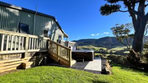 a house with a wooden staircase leading up to a house at Mohua Park - Catlins Eco Accommodation in Owaka