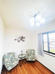 福冈福冈独栋别墅Coco的一间有两把椅子、一张桌子和一扇窗户的房间