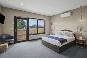 a bedroom with a large bed and a balcony at Evies Cottage i Belmont Suites I regionalXscapes in Belmont