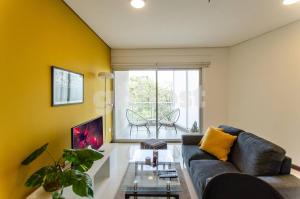 a living room with a couch and a table at Comfy Villa Morra Apt in Asuncion