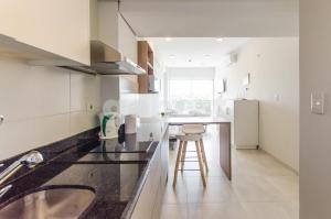a kitchen with a counter and a stool in it at Comfortable Villa Morra Loft in Asuncion
