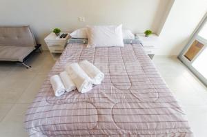 a bedroom with a large bed with towels on it at Comfortable Villa Morra Loft in Asuncion +15 photos