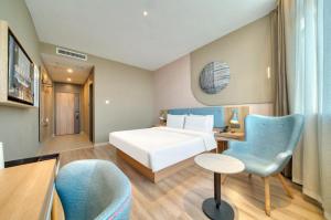 a hotel room with a bed and a desk and a chair at Home Inn Neo Zhuji Zhejiang Agriculture and Forestry University in Shaoxing +152 photos