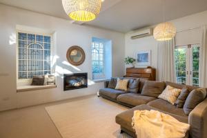 a living room with a couch and a fireplace at Palm Beach Retreat - Be My Guest Waiheke in Waiheke Island