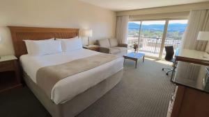 a hotel room with a large bed and a balcony at The Cambridge in Warrane