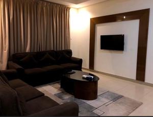 a living room with a couch and a coffee table at ذرا الماضي للشقق المخدومة 1 in Al Bukayriyah