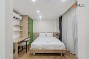 a bedroom with a bed and a desk in it at HongHome Nguyễn Cửu Vân in Ho Chi Minh City