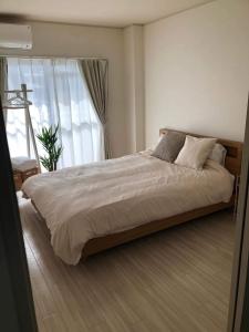 a bedroom with a large bed with a large window at Shimaville Japan, El Corpo in Matsudo