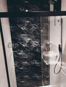 a bathroom with a shower with black marble at Studio 132 Industrial luxury in Mogi das Cruzes +29 photos