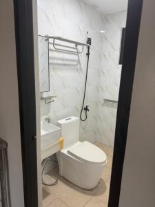 a white bathroom with a toilet and a sink at Amp rental unit in Manila
