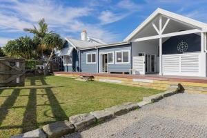 a blue and white house with a yard at Claremont - Timeless Foreshore Retreat by the Wharf in Stockton