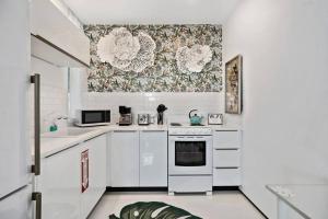 a kitchen with white appliances and a wallpaper at Las Olas Hammocks Unit 3 By Pmi in Fort Lauderdale