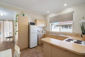 a kitchen with a white refrigerator and a sink at Bayside Bliss Family Friendly, Beach & Jetty in Busselton +12 photos