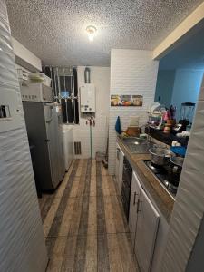 a small kitchen with a sink and a refrigerator at Double bedroom TV cabinet in Soacha