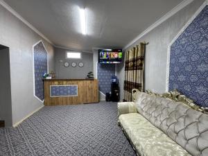 Una sala de estar con un sofá y un televisor. en Alibaba and 40 pirates house, en Khiva