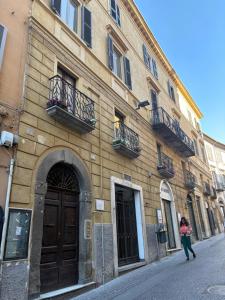 a woman walking in front of a building at Corso Italia 111 guest house in Viterbo