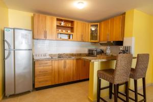 a kitchen with wooden cabinets and a stainless steel refrigerator at Beachfront Cadaques Smart Tv Fullkitchenrest in Bayahibe