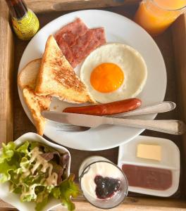 a plate of breakfast food with an egg and toast at Suntria Hotel Pattaya in Na Jomtien