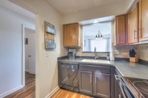 a kitchen with wooden cabinets and a sink and a window at Riverfront Retreat-Near Broadway, Pool, Park Free in Nashville