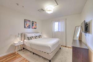 a white bedroom with a bed and a television at Riverfront Retreat-Near Broadway, Pool, Park Free in Nashville +22 photos