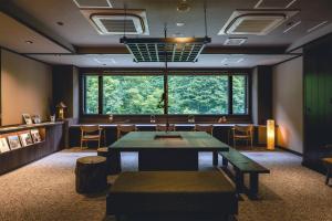 东川町佐渡日式旅馆的一间有桌子、椅子和大窗户的房间
