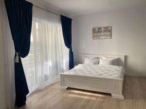 a bedroom with a white bed and a window at Studio Felix Relax MAO 13&14 in Baile Felix