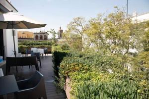 a patio with tables and chairs and an umbrella at Near Templo Mayor Smart Tv Rooftop in Mexico City