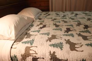 a bed with a blanket with horses on it at Cedar at Rainier Lodge (0.4 m from Mt.Rainier) in Ashford