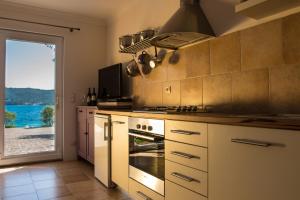 cocina con fogones y vistas al océano en Waterfront Apartment, en Kućište 17 fotos más