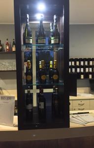 a display case filled with bottles of wine at Hotel Motel Galaxy Reggio Emilia in Reggio Emilia