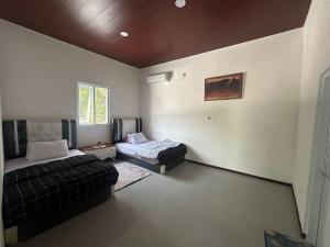 ein Wohnzimmer mit einem Bett und einer Couch in der Unterkunft Hotel daundaun in Tjikakaka
