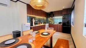 a kitchen with a wooden table with plates and glasses on it at Soho House Old Town Bangkok in Bangkok