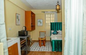 a small room with a bed and a kitchen at Verdant Cozy Studio with WI-FI in Nanyuki