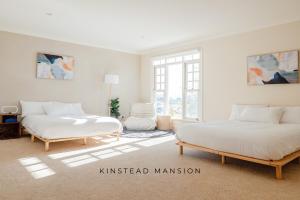 two beds in a room with white walls at Kinstead Mansion - Your exclusive modern country escape in Warragul +20 photos