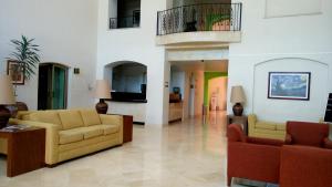 a living room with two couches and a tv at HG Hotel in Guadalajara