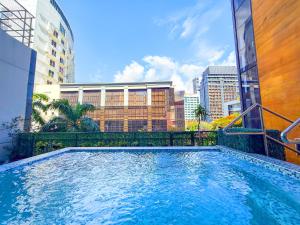 ein Schwimmbad mitten in einer Stadt in der Unterkunft The B Hotel Alabang in Manila