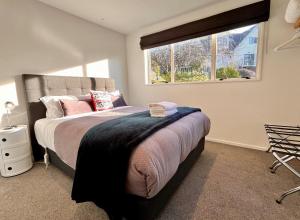 een slaapkamer met een groot bed en een raam bij Sunnyview - Lake Tekapo in Lake Tekapo +7 foto's