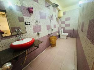 a bathroom with a red sink and a toilet at Zero Mile Rooms in Begusarai