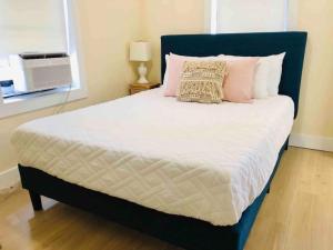 a bed with a blue headboard and pink pillows at Pets Ok Steps 2 Ocean Center Walk 2 Beach in Daytona Beach