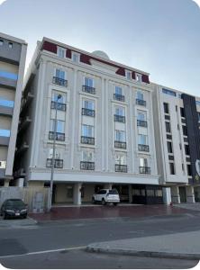 un gran edificio blanco con un coche aparcado delante de él en Modern studio, en Yeda