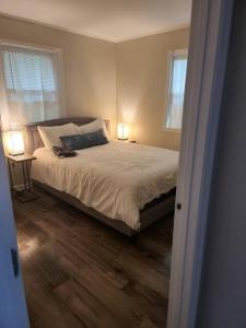 a bedroom with a bed with two windows and two lamps at 3 Bedroom Cozy Home Minutes From Tims Ford Lake in Winchester