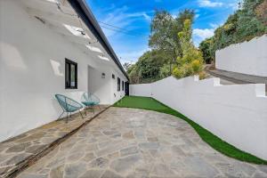 a patio with two chairs and a white wall at 4BR Hilltop Villa by Universal Studios with Pool and Amazing Views in Los Angeles +34 photos