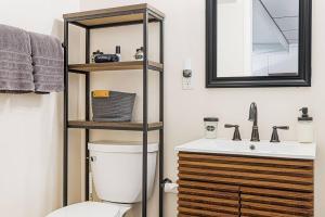 Un baño con inodoro, lavabo y espejo. en Romantic Garden Studio - 1br - Indoor Fireplace, en Leicester