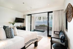 Un dormitorio con una cama y vista al mar. en Batu Karang Lembongan Resort & Spa, en Nusa Lembongan