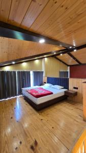 a large bed in a room with a wooden floor at Rosewood Cottage in Mukteshwar
